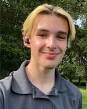 Jonathan May wearing a grey polo outdoors