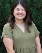 A headshot of Sarah Grabber in a green dress